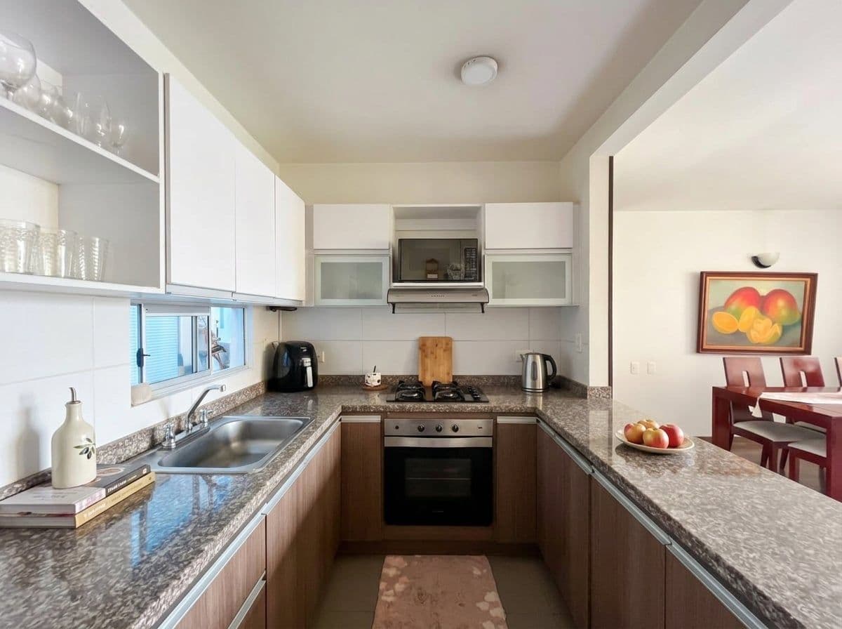 Cocina semi-integrada con mesón en granito y estufa a gas