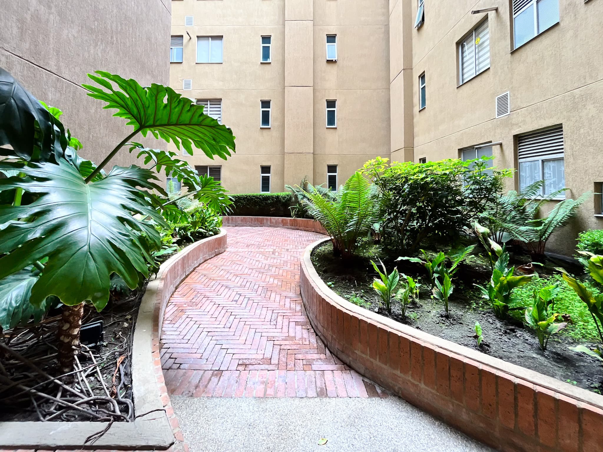 Jardines interiores del conjunto con senderos en ladrillo
