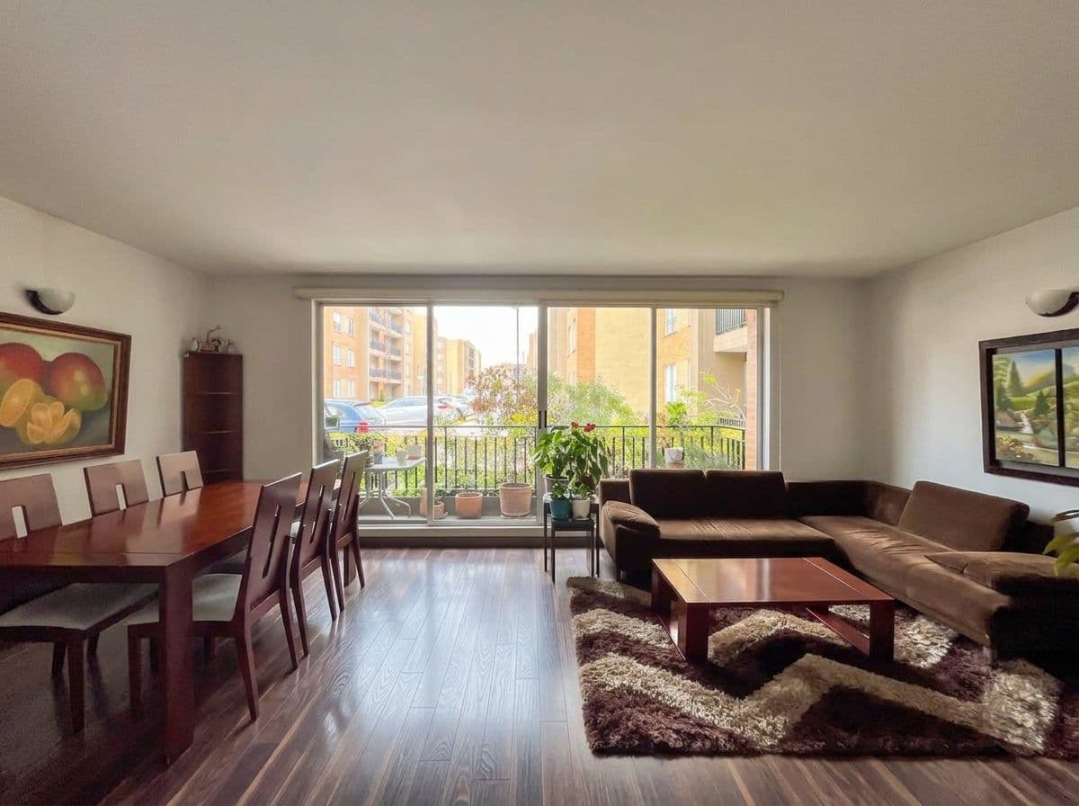 Sala y comedor con grandes ventanales y piso en madera