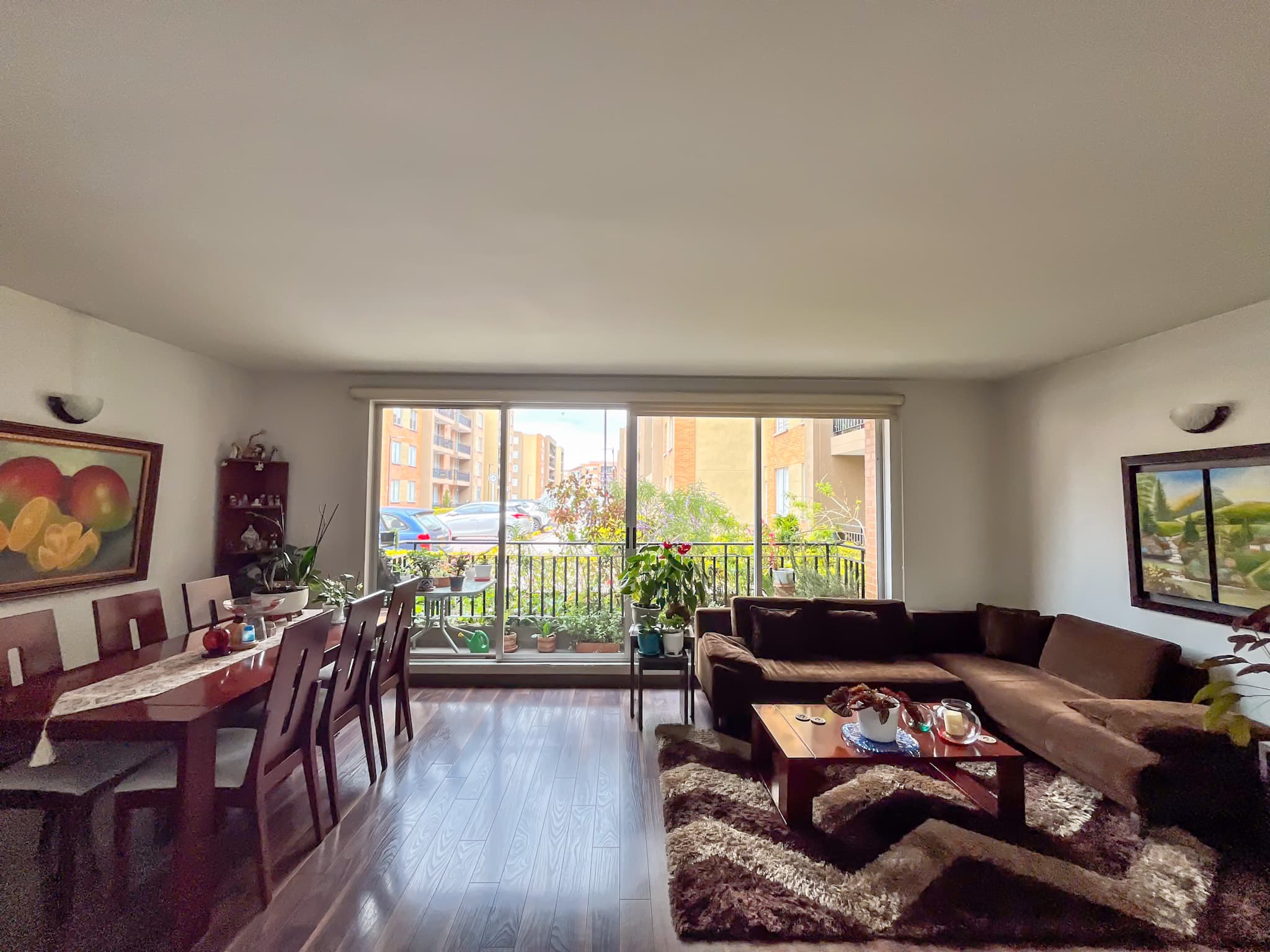 Sala y comedor con grandes ventanales y piso en madera